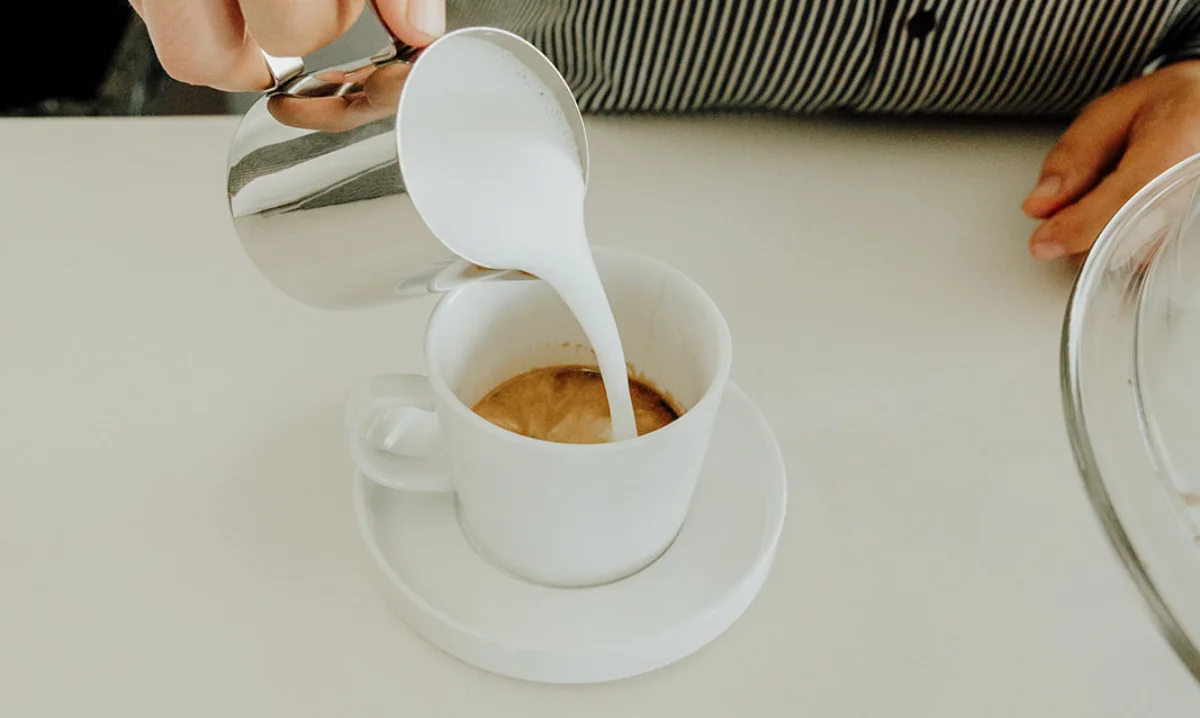 Coffee creamer being poured in coffee